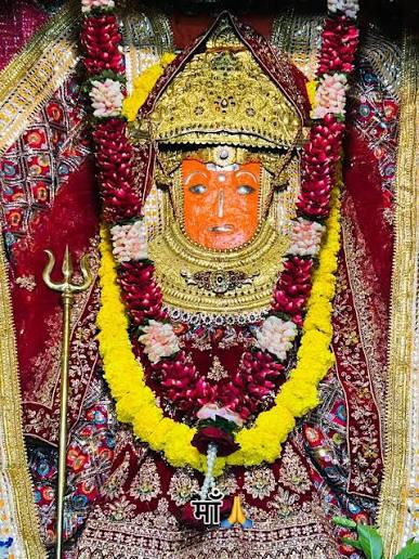 Shri Jeen Mata in golden mukut with rose and marigold garlands and silver trishul during evening shringar at Sikar